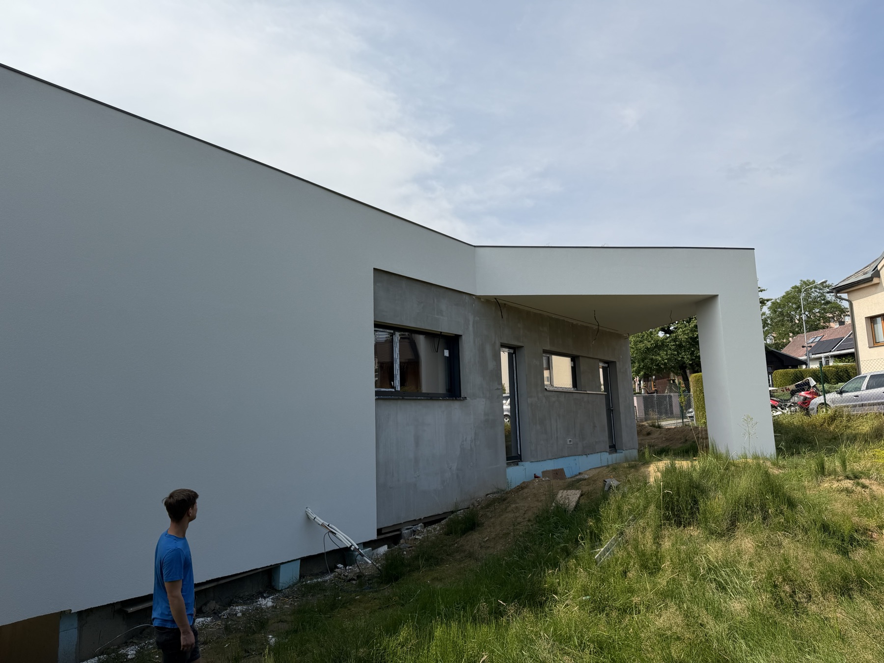 Dokončená bílá fasáda rodinného domu s hladkým povrchem
