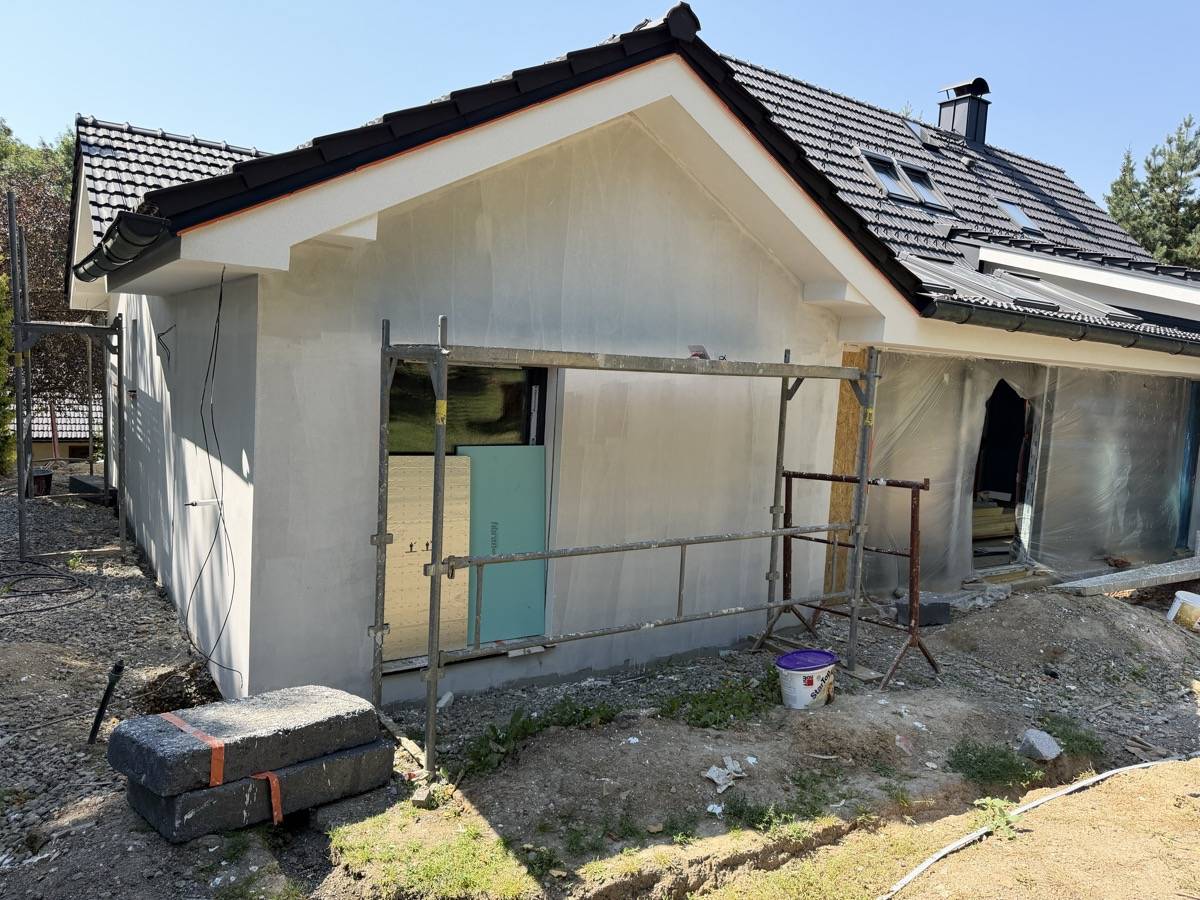 Rodinný dům se stěrkovou vrstvou před finální omítkou, postavené lešení